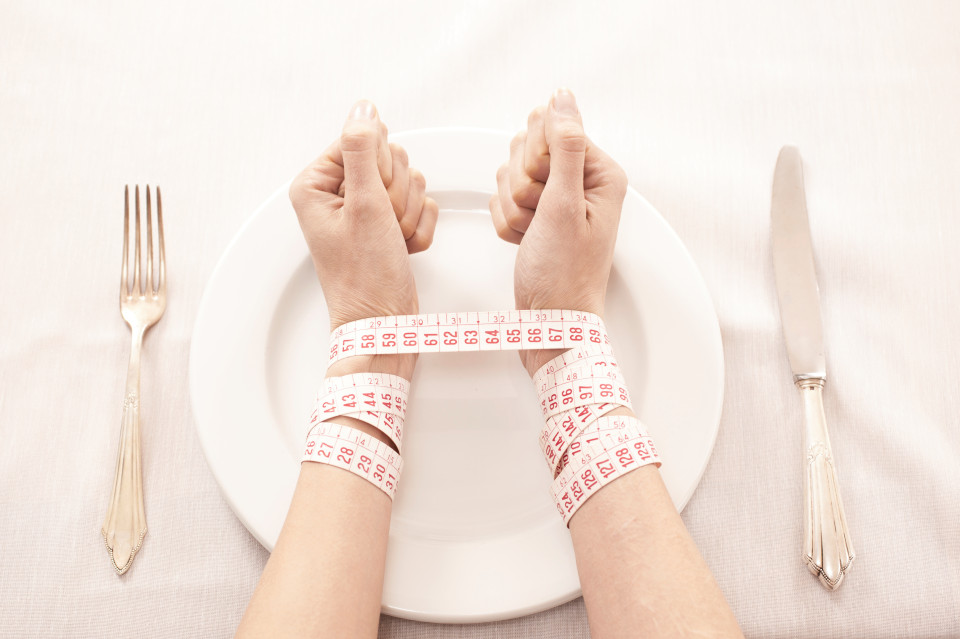 eating disorder hands on plate image